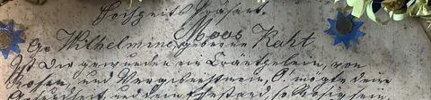 Close crop of the opening lines of the 1882 wedding greeting in old German Kurrent handwriting, naming a wreath of roses and forget-me-nots